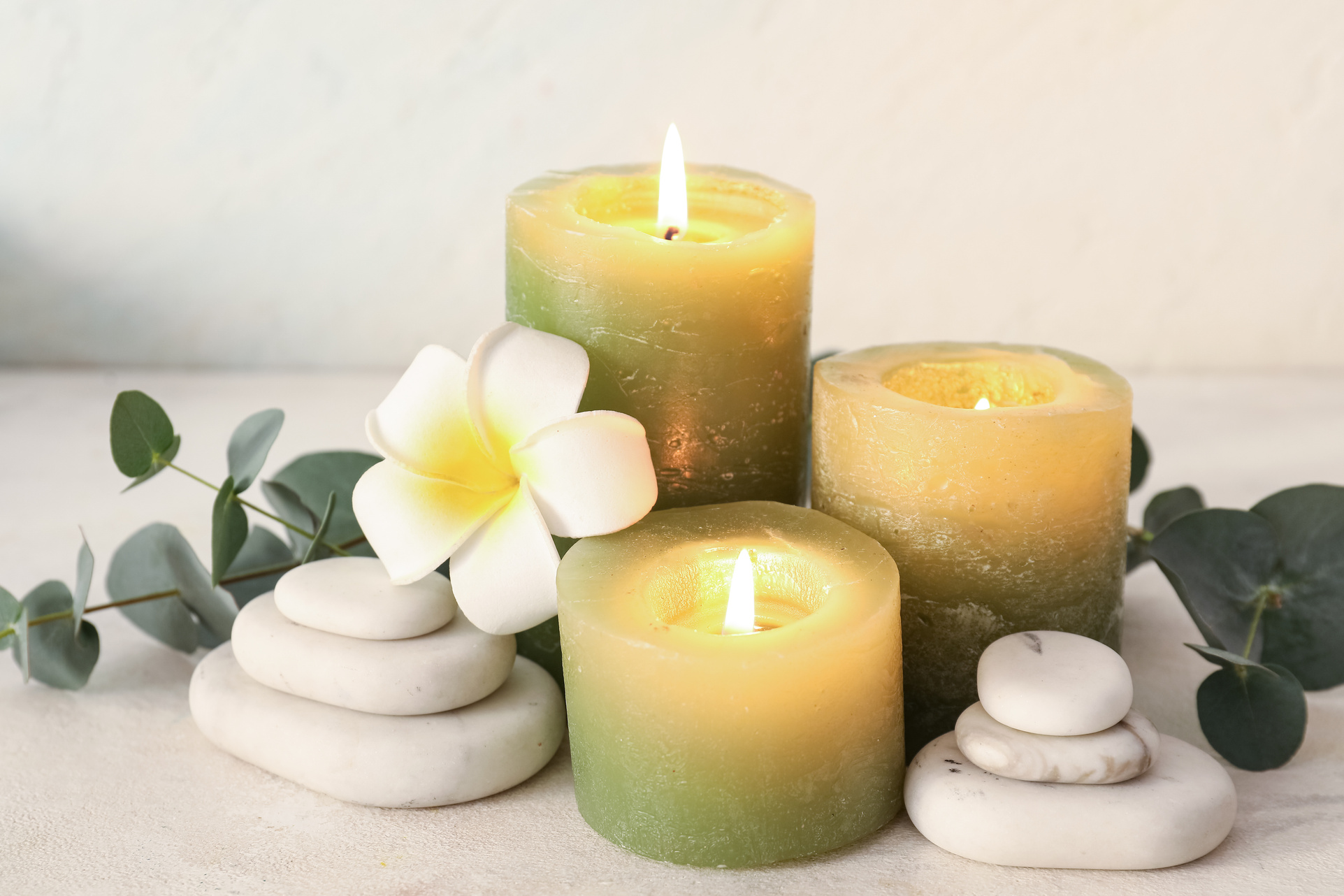 Green sage candles and stones — calming spa setting